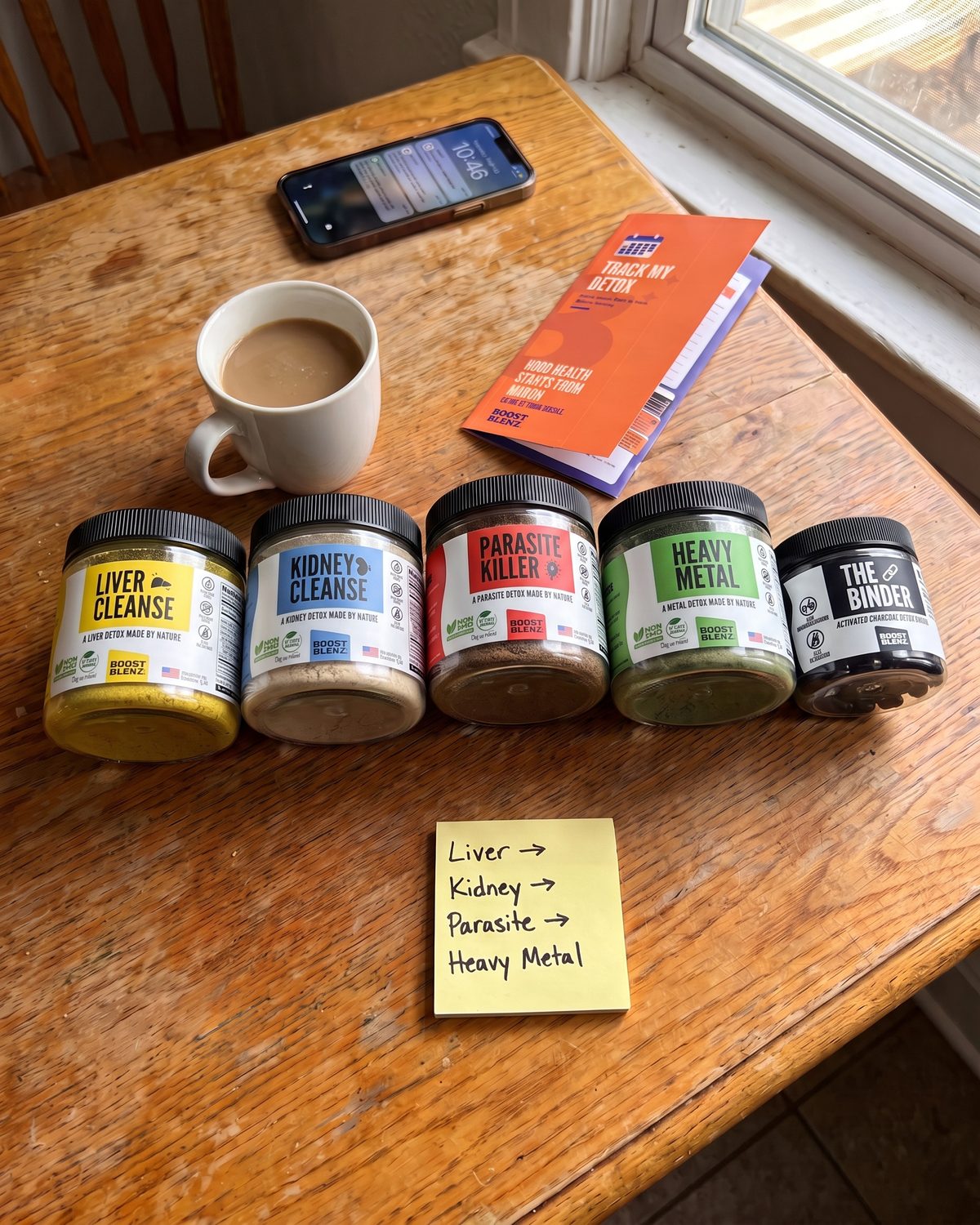 Liver, Kidney, Parasite, Heavy Metal and the Binder lined up in order on a kitchen table with a sticky note